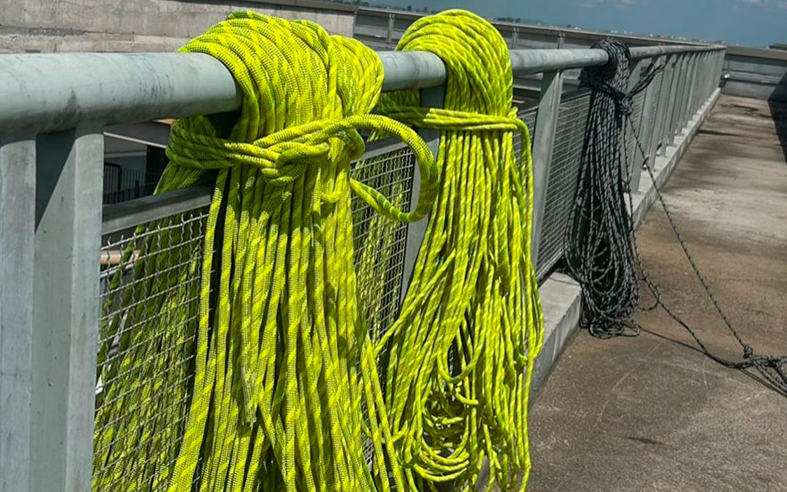 Alpinista industrial guiando peça estrutural para montagem